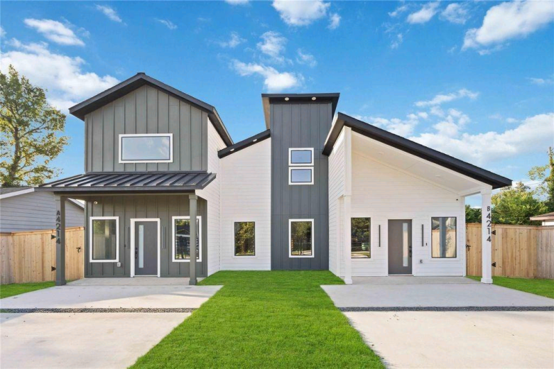 Completed Cross Builds modern duplex with gray and white board-and-batten exterior and lush green lawn in Houston