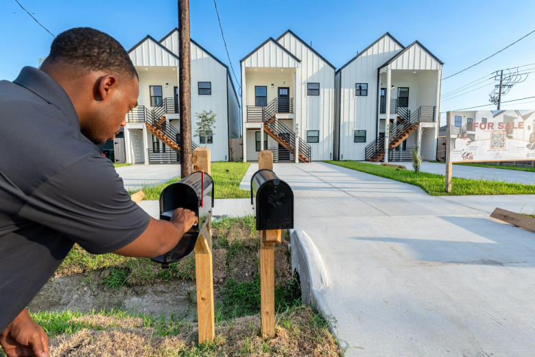 Cross Builds team member at mailbox in front of completed Pelsey Triplets home for sale in Houston